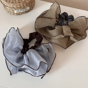 Close-up of large chiffon scrunchies with contrasting edges in sky blue and khaki colors