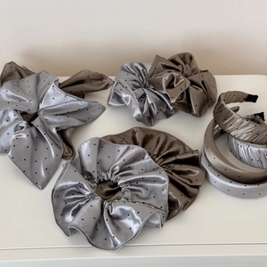 Close-up of elegant satin polka dot hair scrunchies and headbands in mocha and silver grey