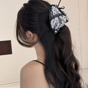 Detailed back view of a satin polka dot bow hair claw with lace and a pearl accent