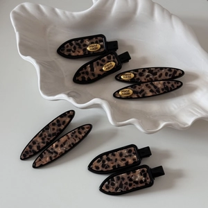 Close-up of tortoise shell leopard print hair clips with gold Hand Made metal labels