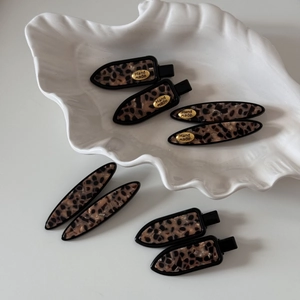 8-piece leopard tortoiseshell hair clip set in a white ceramic shell display dish