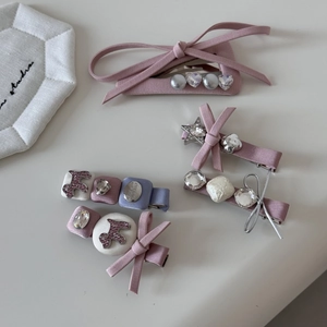 Détail de barrettes roses avec perles, strass et broderies en forme de cœur délicates