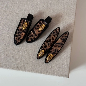 Retro leopard print hair clip set with gold hand made tag on beige canvas background