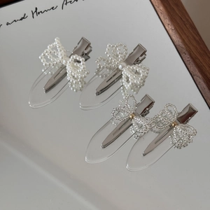 Chic pearl bow hair clip set with four pieces on a mirror surface for women and girls