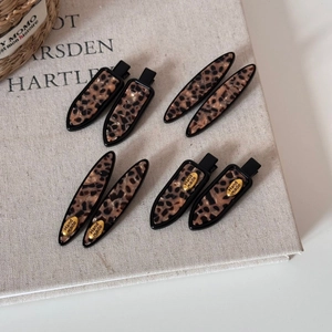 Detail view of tortoiseshell leopard print hair clip set with gold hand made metal labels