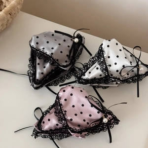 Close-up of satin hair clips with lace edges, polka dots, bows and pearl details