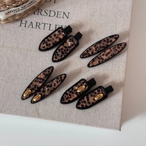 Detail of tortoise shell leopard print hair clips set on rustic canvas background
