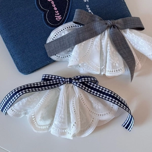 Detail of preppy lace hair clips featuring grey and blue checkered bows with embroidery