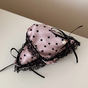 Detailed view of pink satin hair claw with black polka dots, lace edges and pearl pendant