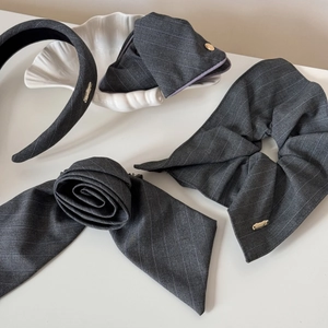 Set d'accessoires cheveux à rayures grises avec serre-tête et chouchou sur fond blanc
