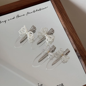 Detailed view of handmade pearl and crystal bead bow hair clips with silver metal duckbill