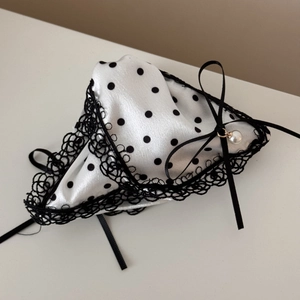 Close-up of satin polka dot hair clip with black lace trim and pearl ribbon bow