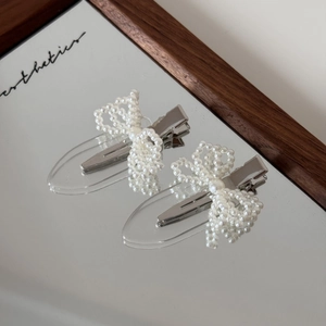 Set of two pearl bow hair clips with transparent base and silver duckbill clips for girls