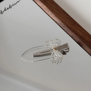 Detailed macro of the handmade clear beaded bow hair clip with a silver metal duckbill base