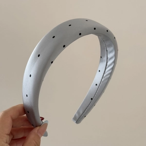 Detail of grey padded satin headband with black polka dots and soft foam filling