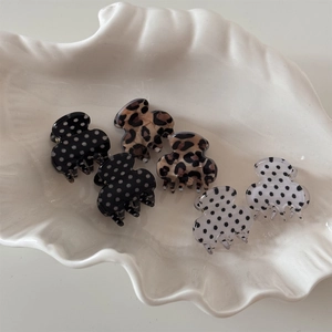 Mini polka dot and leopard print hair clips displayed in a white ceramic shell tray