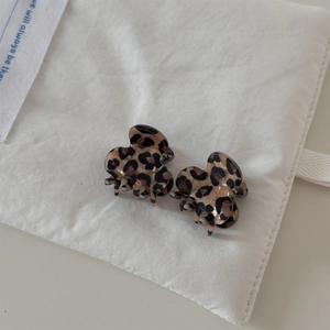Close-up of mini leopard print hair clips made of acetate resin on a beige fabric bag