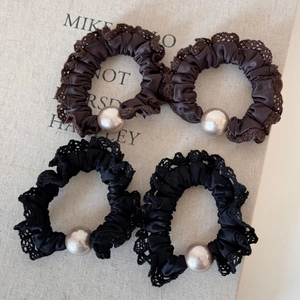 Set of four satin scrunchies with elegant lace trim and large pearl accents in neutral tones