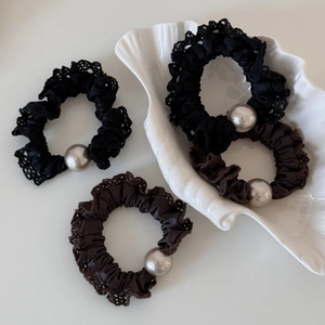 Close-up of lace fabric hair scrunchies with large pearls in black and coffee brown