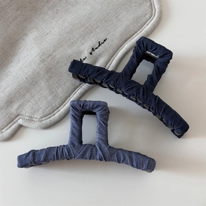 Detail of vintage denim-wrapped hair claws showing rich fabric texture and multi-teeth grip