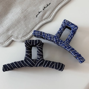 Detail view of handmade vintage striped denim hair claws with fabric texture and patterns
