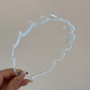 Gros plan d'un serre-tête ondulé transparent couleur gelée avec dents antidérapantes