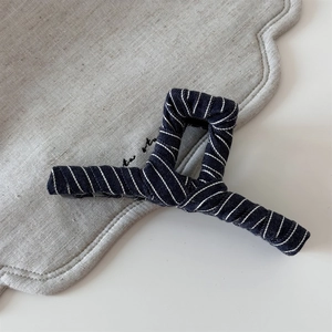 Detailed view of the navy blue striped fabric texture on the geometric hair claw clip