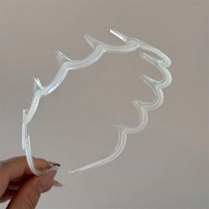 Détail d'un serre-tête ondulé transparent avec dents antidérapantes en résine brillante