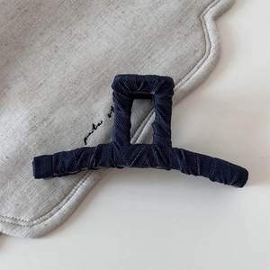 Detail shot of the vintage striped denim fabric texture on a square hair claw clip