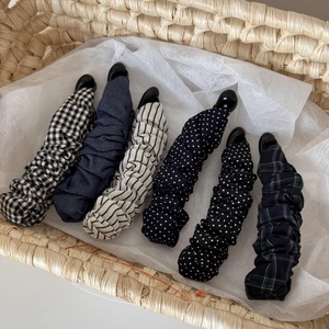 Nahaufnahme von Vintage-Bananenclips mit Punktemuster und Karostoff im Korb