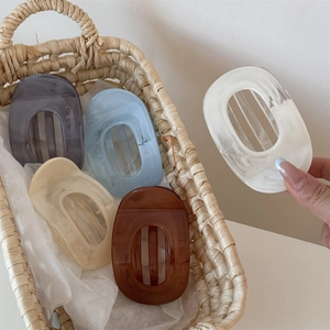 Elegant marble acetate hair claw clips in five pastel colors inside a woven basket