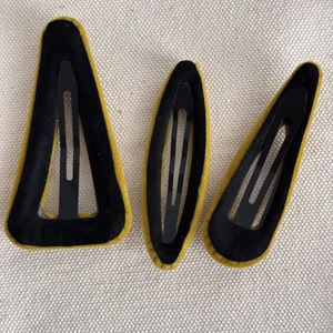 Détails du revers des barrettes en velours montrant les boucles métalliques noires