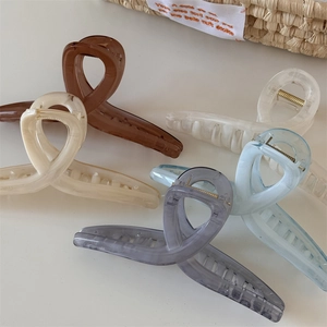 Cinque grandi pinze per capelli in resina marmorizzata in colori pastello su bianco