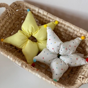 Chouchous en forme d'étoile jaune et blanc à pois présentés dans un panier tressé
