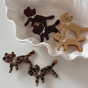 Detailed close-up of cat-shaped acetate hair clips in leopard and brown patterns