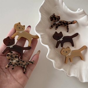 Close-up of leopard print acetate cat hair clips set with white bow decorations