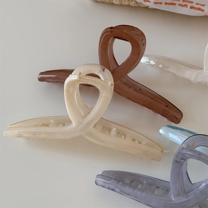 Dettaglio di pinzette per capelli in resina color gelatina in caldi toni neutri
