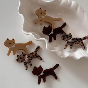 Retro acetate cat hair clips in leopard and mustard yellow displayed on a shell tray