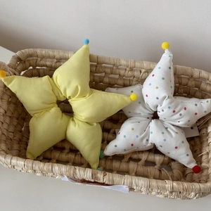 Gros plan de chouchous en tissu en forme d'étoile avec pompons colorés en panier