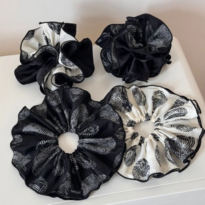 Set of four pleated scrunchies in black and white patterns for ponytail hairstyles