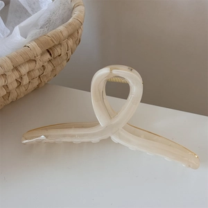 Vista dettagliata di una grande molletta per capelli crema con trama marmorizzata