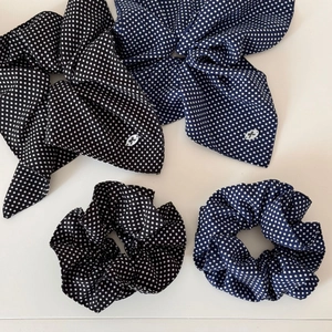 Detailed flat lay of polka dot fabric scrunchies with long bows in black and blue