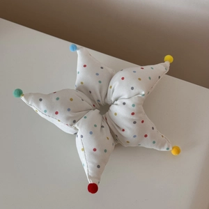 Détail d'un chouchou en forme d'étoile avec pois colorés et mini boules en peluche