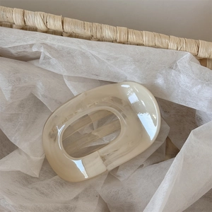 Close-up of cream marbled acetate hair claw clip showing smooth texture and oval shape