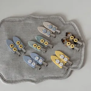 Set van 12 madeliefje haarklemmen van acetaat in diverse pastelkleuren op matje