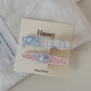 Détail de barrettes à pois roses et carreaux bleus avec perles sur carte