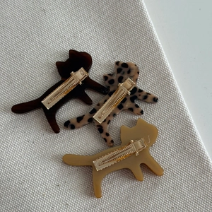 Three acetate cat hair clips in leopard print and amber finish with gold metal duckbill