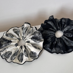 Close-up of pleated scrunchies set in black and white tones with texture details