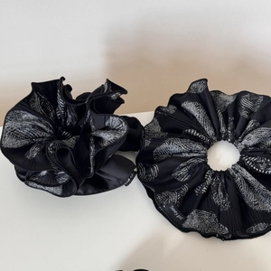 Close-up of pleated black chiffon scrunchies with white leaf pattern and Sweety girl label