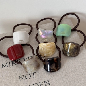 Macro detail of geometric acetate hair ties in various marble textures and colors